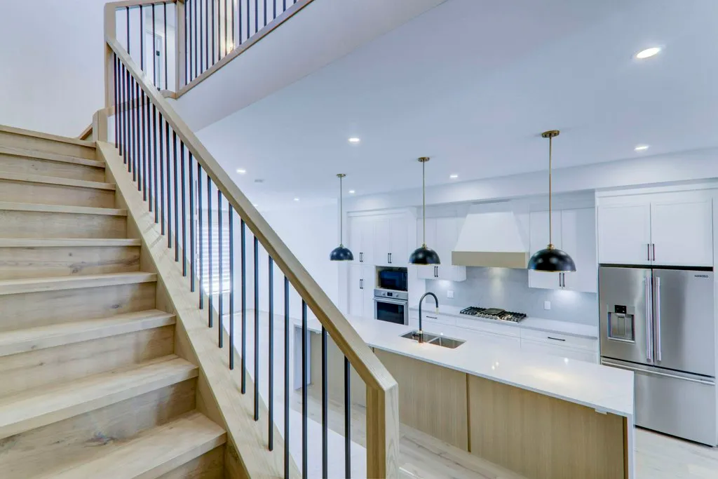 A bright staircase and kitchen in a Calgary home managed by NEXA